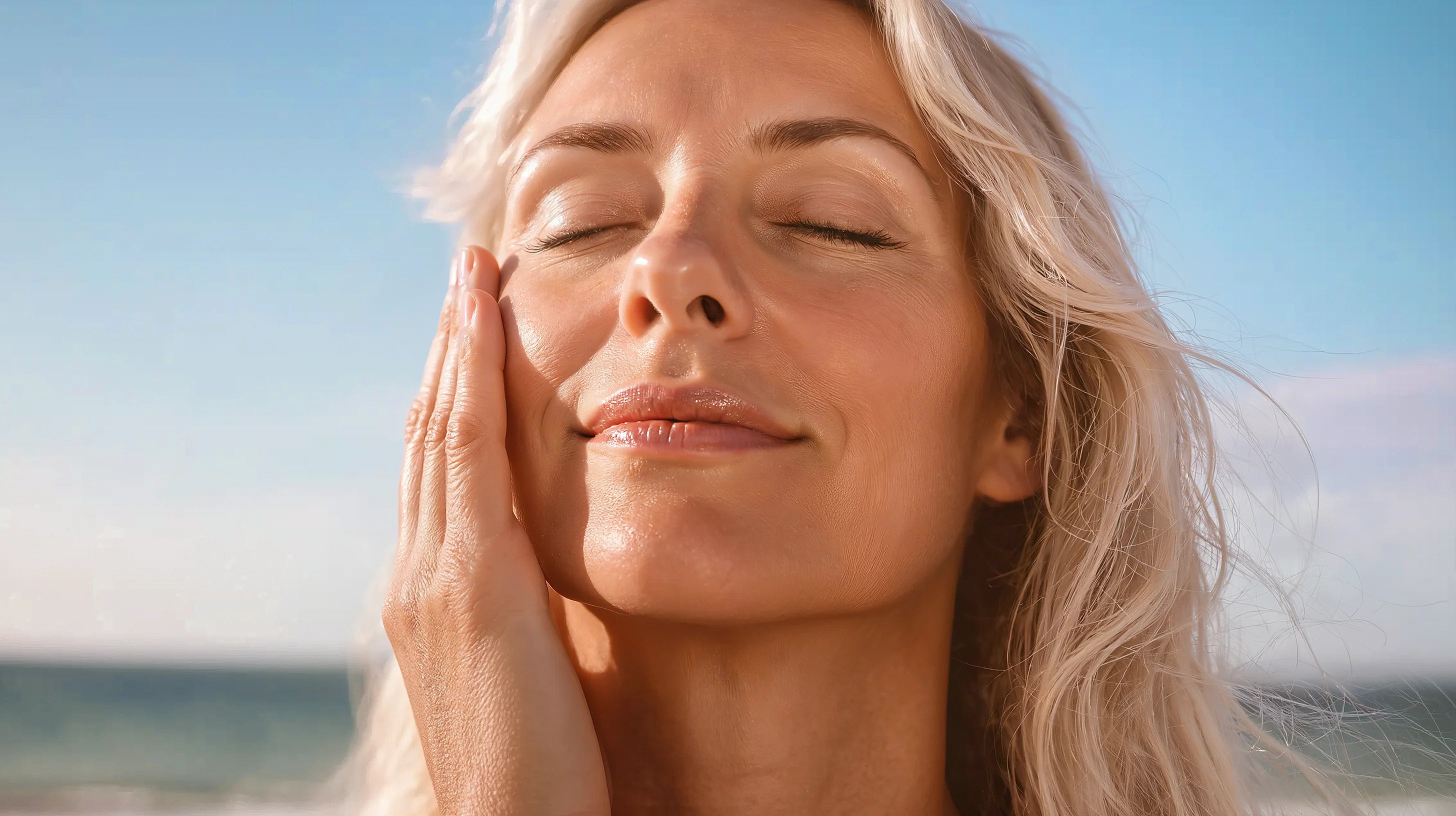 Woman with closed eyes on a beach with clear blue sky